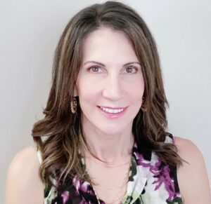 Woman posing for a headshot photo against a white background