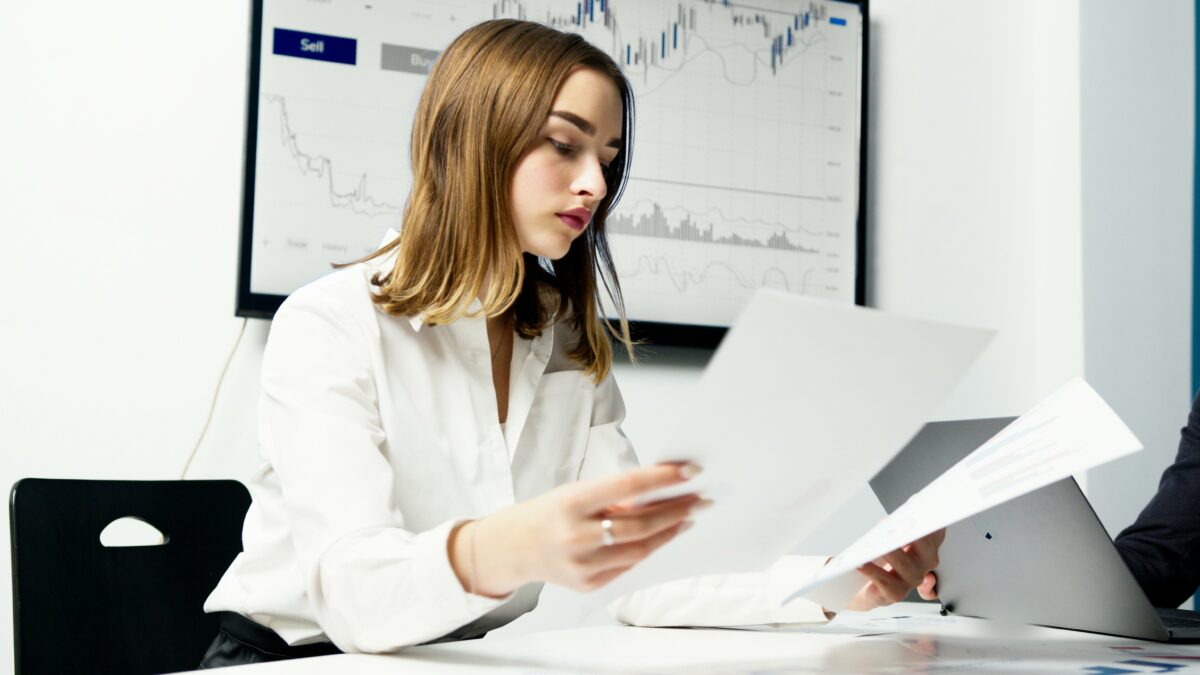 Woman in office comparing two documents.