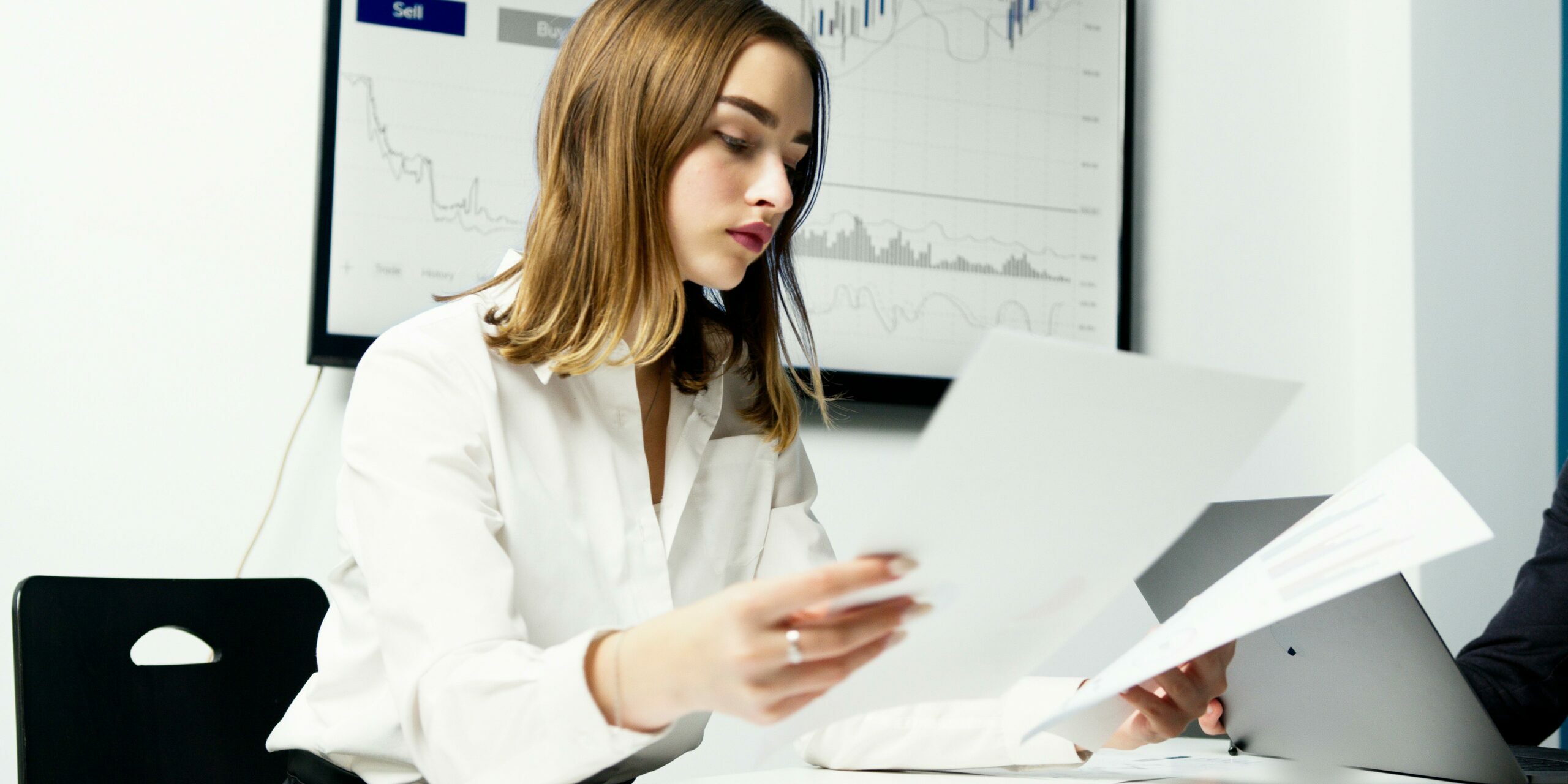 Woman in office comparing two documents.