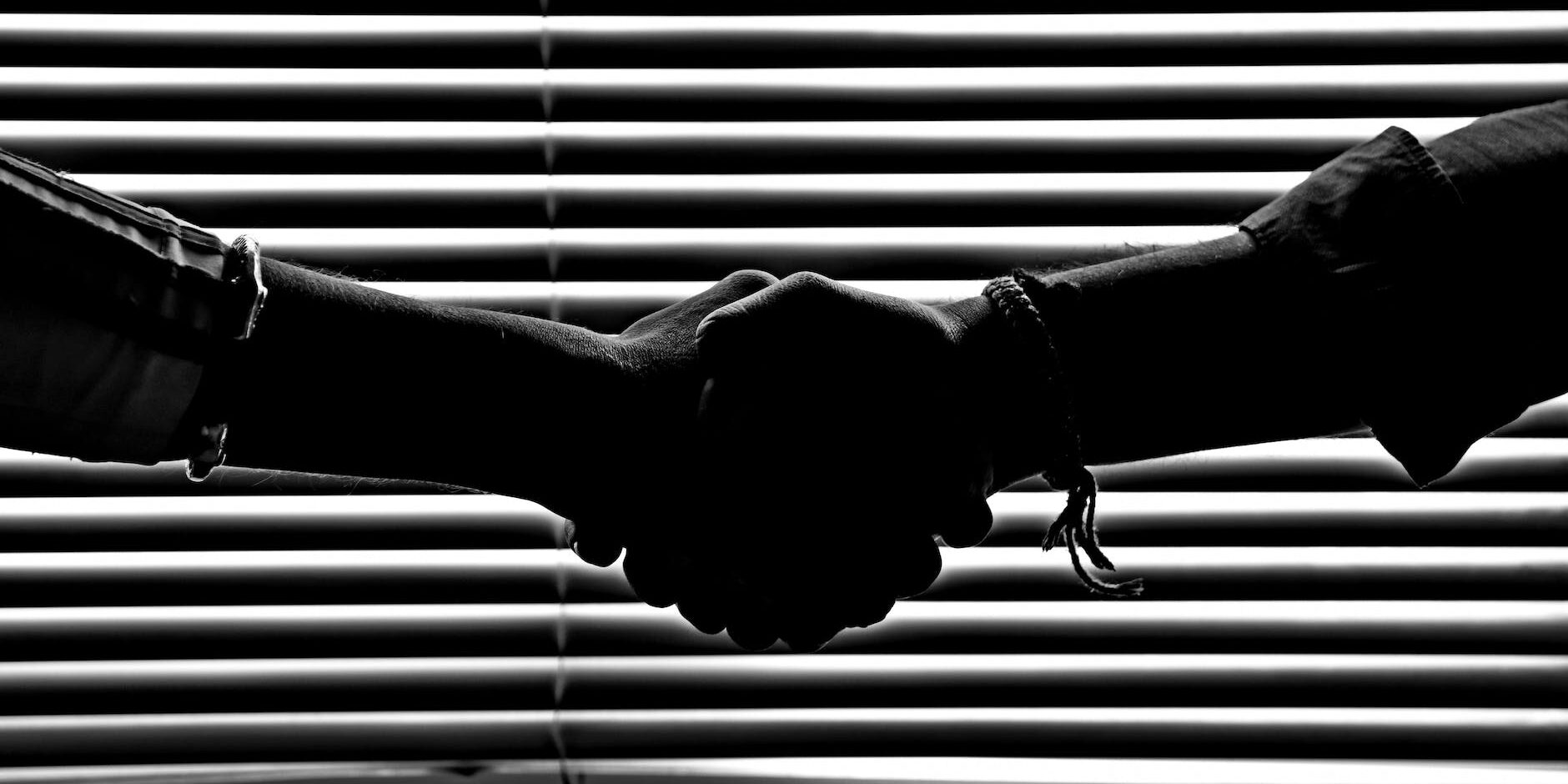 monochrome photography of people shaking hands