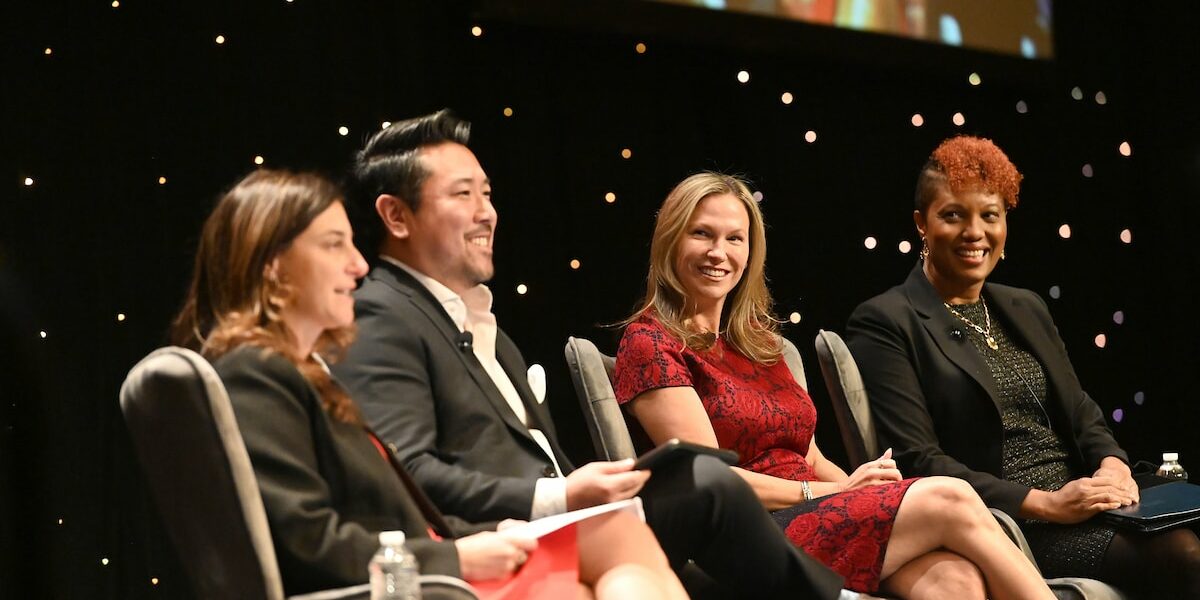 Group of PLUS speakers on stage at the PLUS Conference