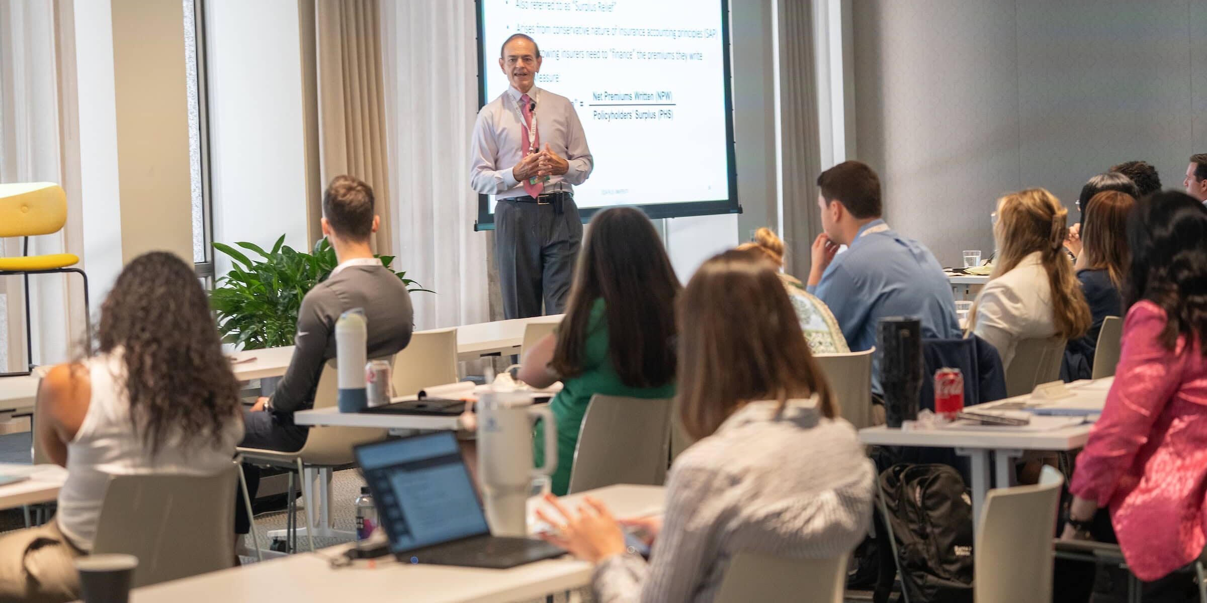 A speaker at the 2024 PLUS University in Chicago with a room full of attendees.