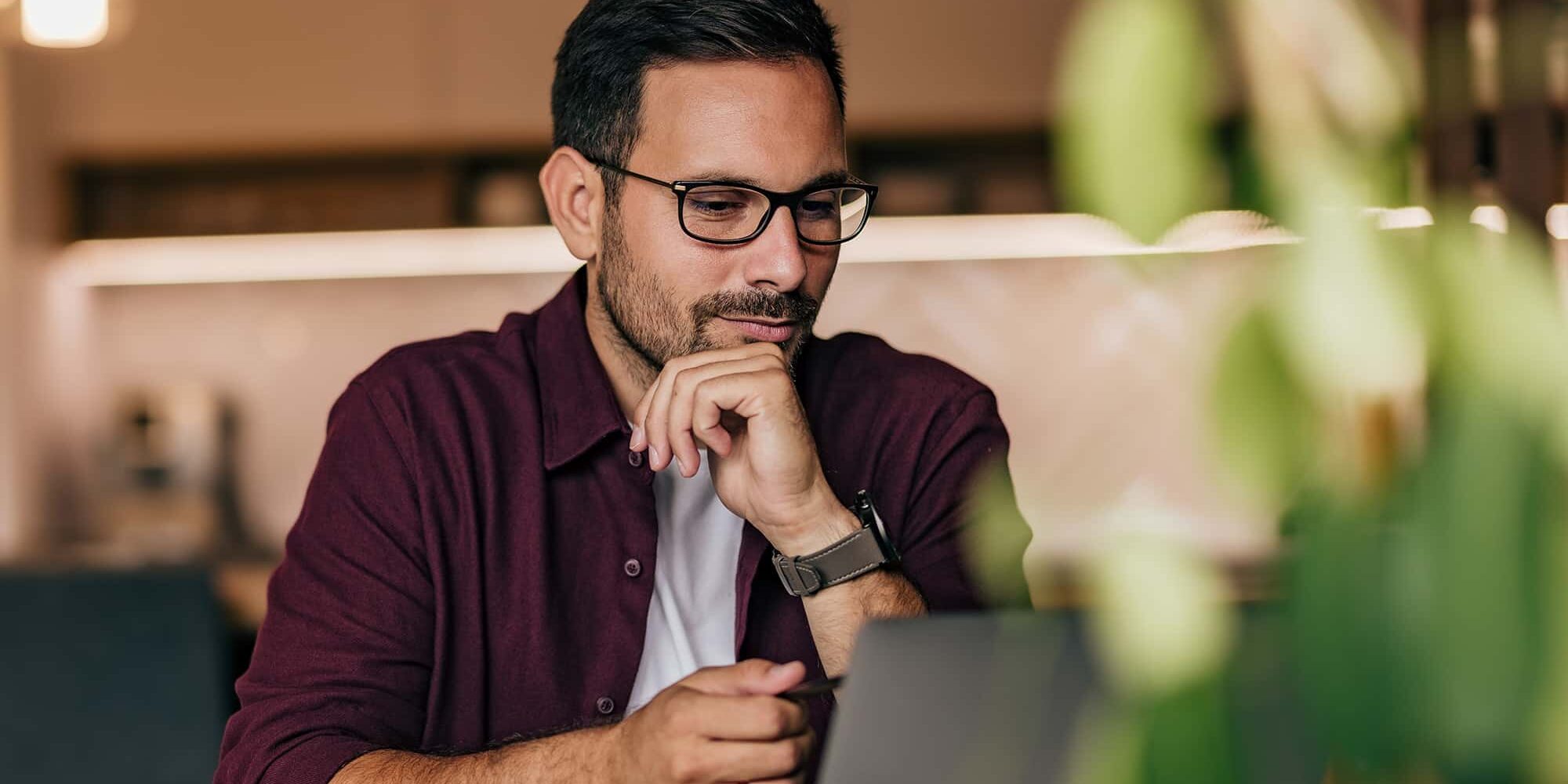A man working online, over the laptop, having a meeting, talking to his clients.