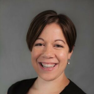 Woman smiling for a headshot photo against a white background