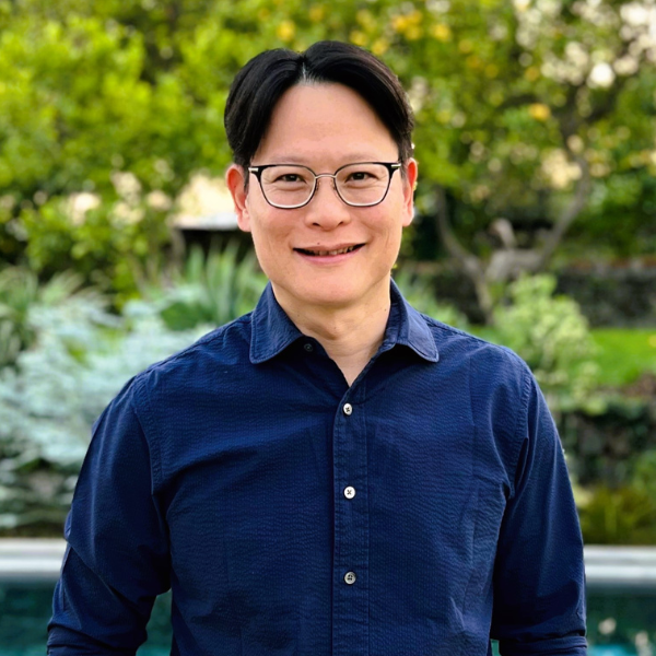 Headshot of Aaron Yip with tree foliage in the background.