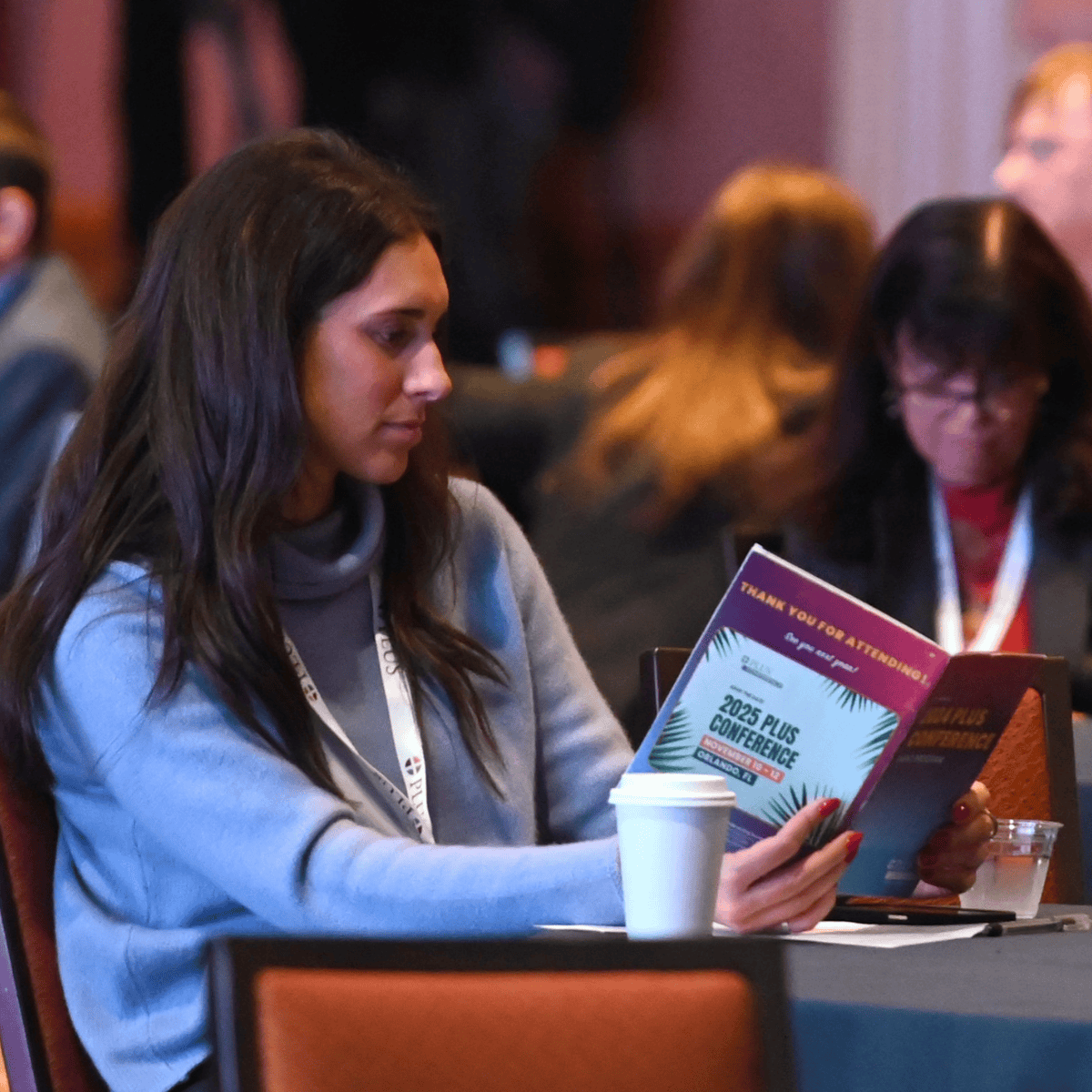 A PLUS member reading the program at the 2024 PLUS Conference