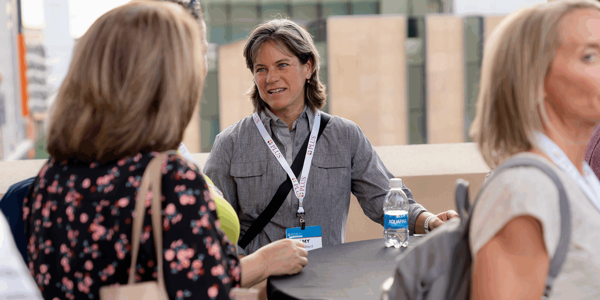 Image of PLUS members gathered around a table talking