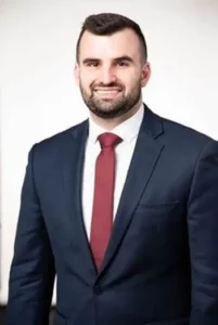 Man smiling for a headshot photo against a white background